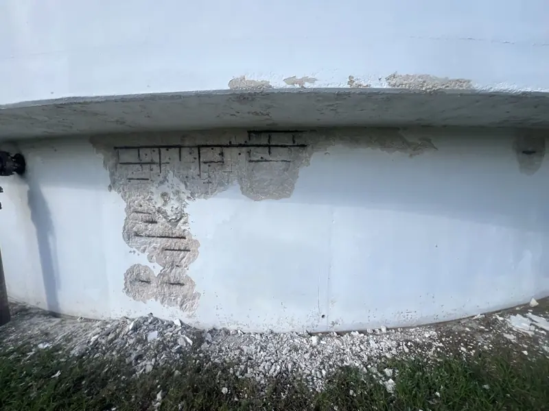 Before: spalled concrete on the tank wall